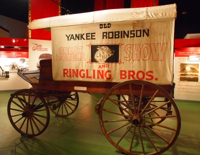 [Side view of an all-wood buckboard wagon with a white canvas top with the words, 